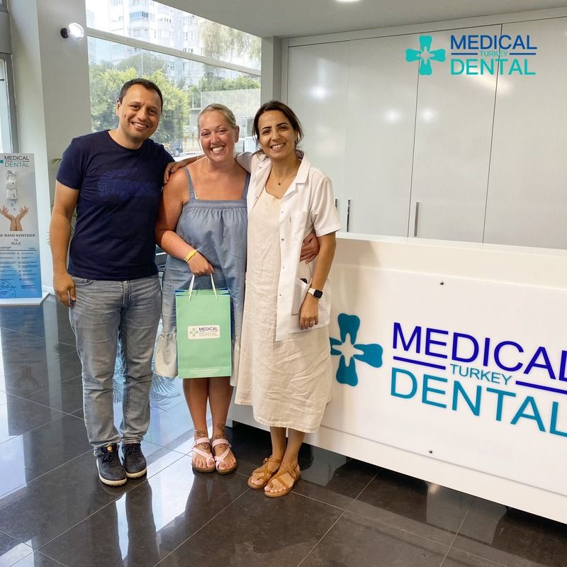 patient sitting in a dental clinic and smiles and a dentist standing behind her